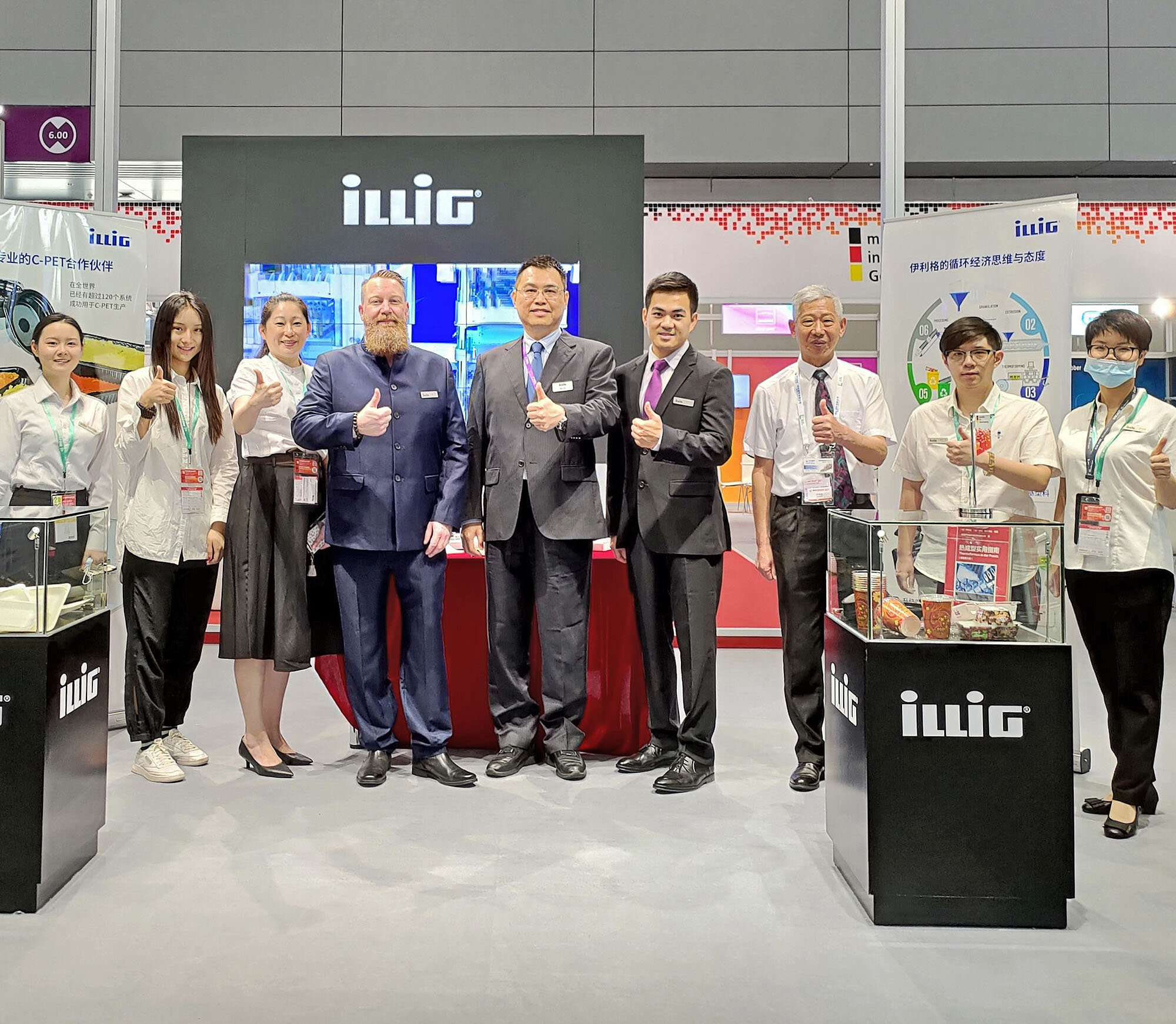 Great success for ILLIG at Chinaplas 2021: Booth staff with thumbs up. | © ILLIG Maschinenbau GmbH